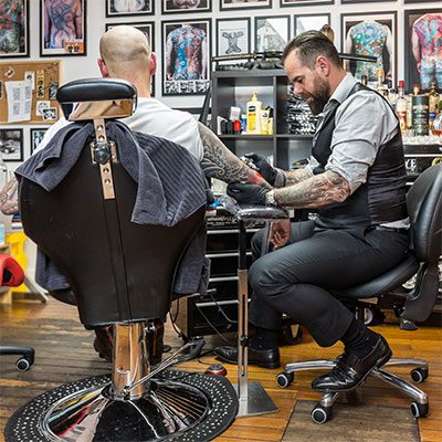 Tattooist using Bambach saddle seat Tattooist using Bambach saddle seat
